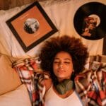 Un momento de paz con una mujer relajándose en el interior, rodeada de discos de vinilo y tonos cálidos.