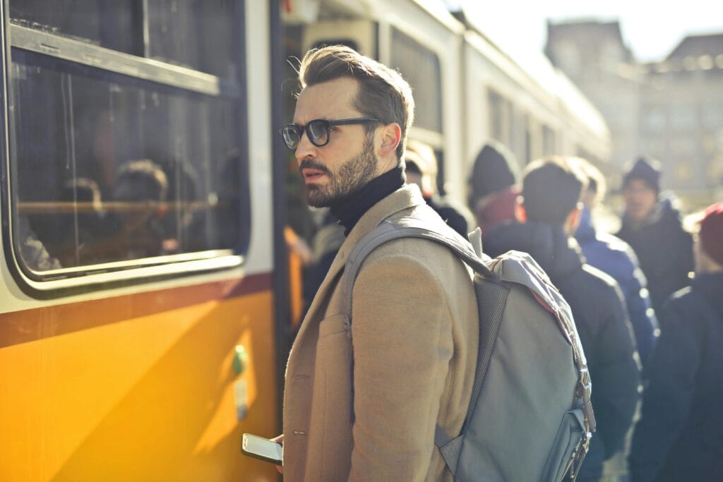Un elegante hombre con una mochila aborda un tranvía en la bulliciosa Budapest, Hungría, durante el día.